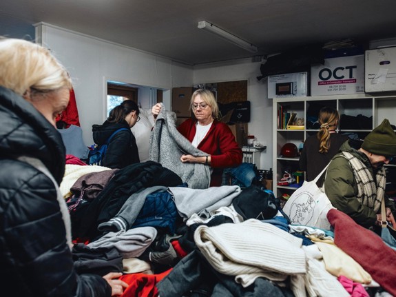 Volontär viker kläder på Röda Korsets hus