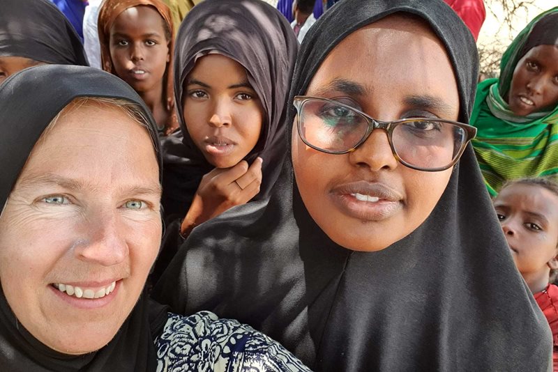Helena Forslund tillsammans med Fatuma, en kollega från IFRC (rödakorsfederationen). En av flickorna som står bakom är 17 år och har kommit till kliniken med sitt yngsta barn som är undernärt. Hon kom till kliniken tillsammans med sin egen mamma.