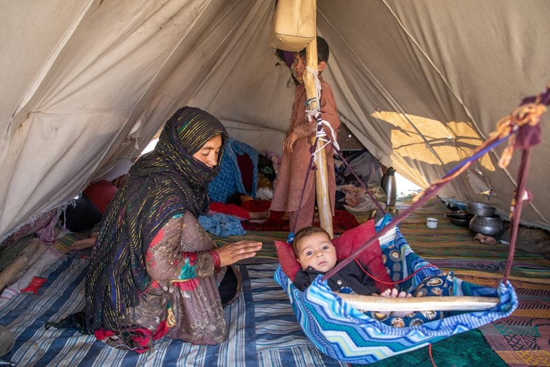 Kvinna med barn - Afghanistan, de sitter inne i ett tält.